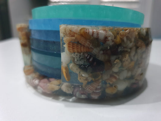 Stackable ocean coloured coasters in seashell stand